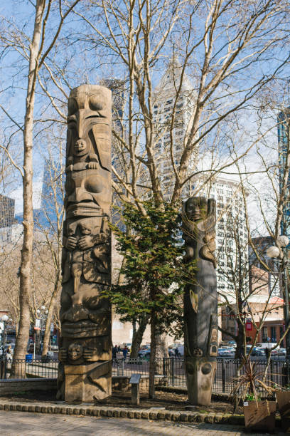 тотемный столб на пионерской площади в сиэтле - native american statue wood carving стоковые фото и изображения