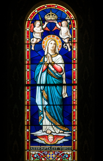 Very old stained glass window depicting the assumption of the Blessed Virgin Mary