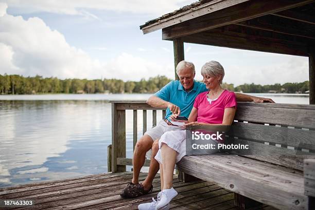 Senior Couple Using Mobile Phone To Deposit Bank Check Stock Photo - Download Image Now