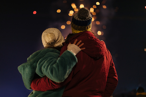 A love couple is enjoying looking at the fireworks during the Christmas holidays