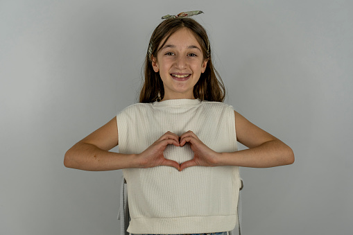Girl smiling with white background. It's the girl making the okay sign.