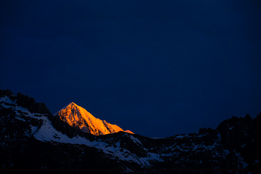 The highest mountain in New Zealand lighted up by sun set in orange.