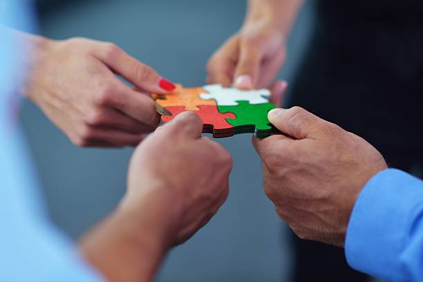 istock Group of business people assembling jigsaw puzzle 187466209