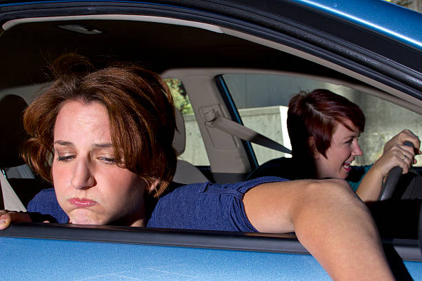 istock Woman looking sick with head out the blue car window 187466738