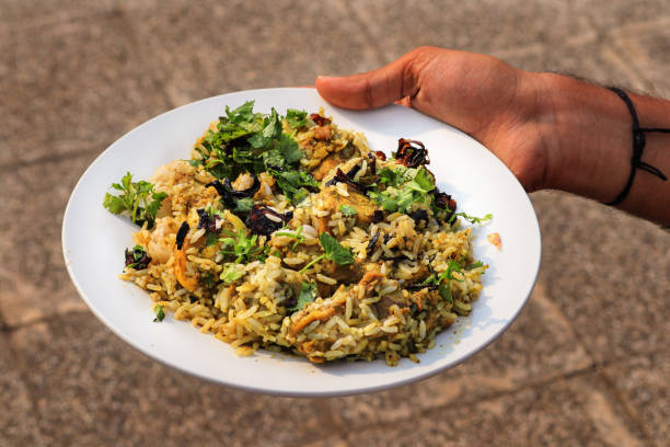 Delicious spicy chicken biryani in white bowl on blur background, Indian food. Chicken Dum Biryani in a Pot on White Background side view Photo. Popular Indian non vegetarian food