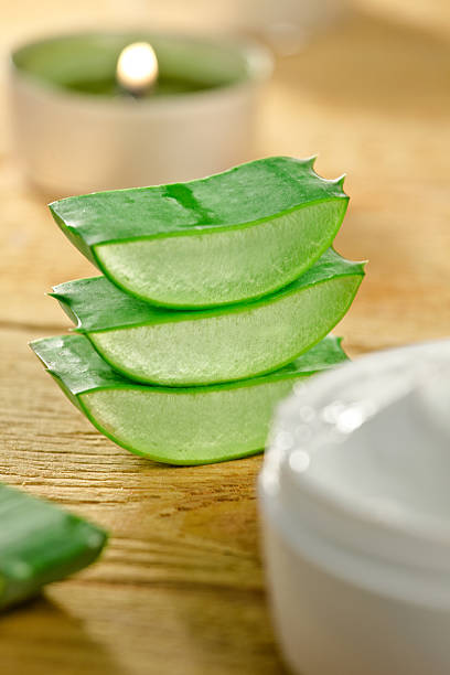 istock Fresh aloe vera slices and cream container on wooden. 187467619
