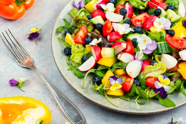 istock Spring salad with vegetables and flowers. 1874698253