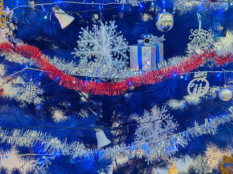 Close-up shot Blue Artificial Christmas Tree With Garland Decorations