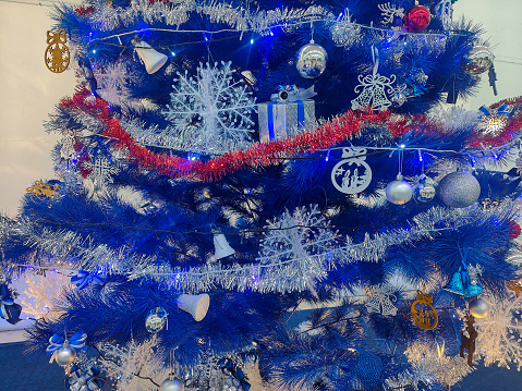 Close-up shot Blue Artificial Christmas Tree With Garland Decorations