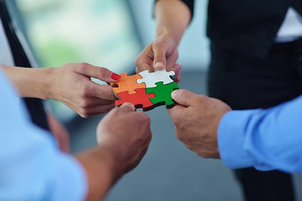 istock Group of business people assembling jigsaw puzzle 187472781