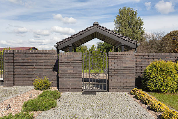 Brick fence and a wicket Brick fence and a metal gateway of a property wicket stock pictures, royalty-free photos & images