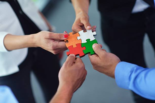 istock Group of business people assembling jigsaw puzzle 187476822