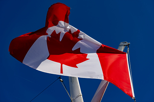 Canadian flag on a flagpole in Gananoque on Lake Ontario.