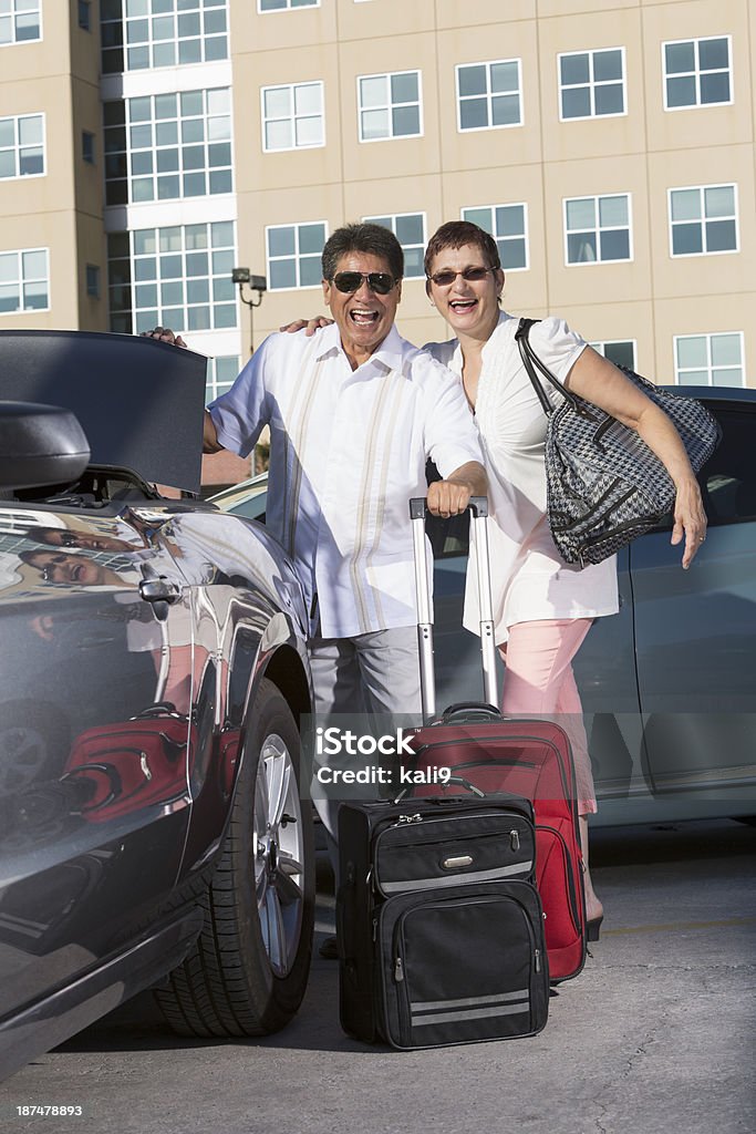 Couple on vacation Mature couple (50s) on vacation, putting suitcases into car trunk.  Focus on man.  Man is Hispanic; woman is mixed race Hispanic and Native American. Car Rental Stock Photo