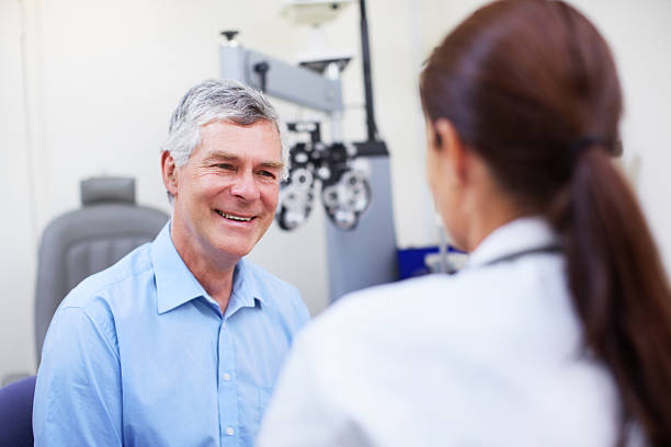 Building a relationship between doctor and patient A young female optometrist speaking to her patient eye care professional stock pictures, royalty-free photos & images