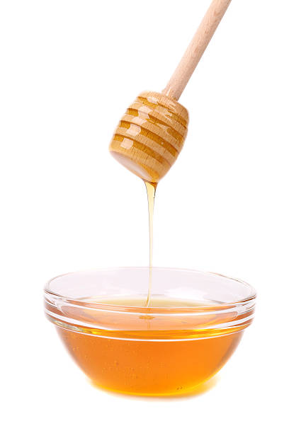 istock Honey dripping from a wooden dipper. 187480420