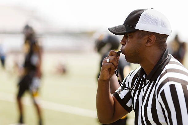 Football Referee A football referee blowing his whistle.    referee stock pictures, royalty-free photos & images
