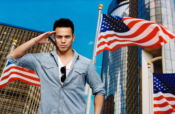 istock Young man saluting in front of American flag 187481221