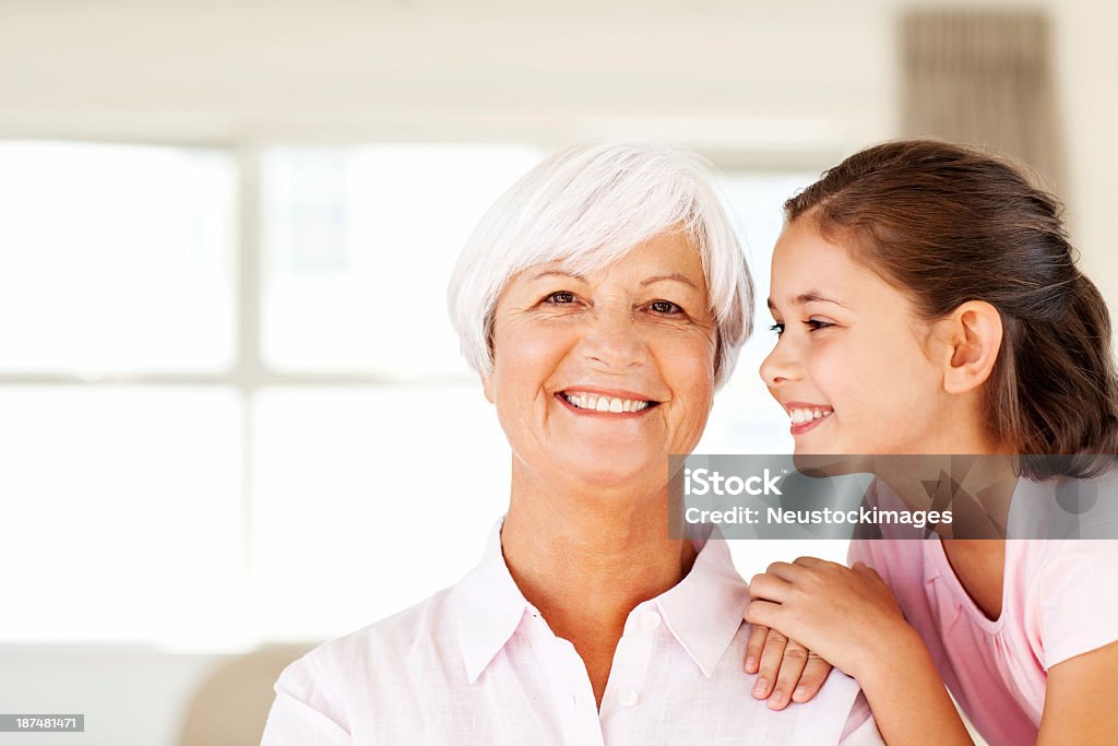 Nonna con nipote su bacio sulla guancia per il - Foto stock royalty-free di 60-64 anni