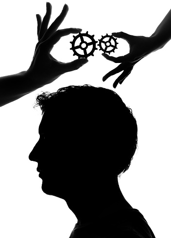 Hand holding gears over a human head