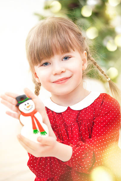 istock Little girl holding snowman ginger cookie 187482709