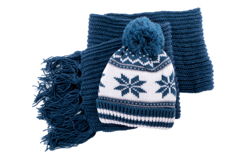 Blue knitted winter bobble hat and scarf isolated against a white background.  Alternative file shown below: