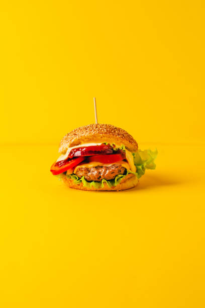крупный план гамбургера на желтом фоне - barbecue beef close up multi colored стоковые фото и изображения