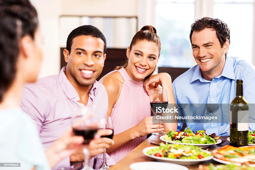 Grupo de amigos sonriente haciendo un brindis en el restaurante - Foto de stock de 20 a 29 años libre de derechos