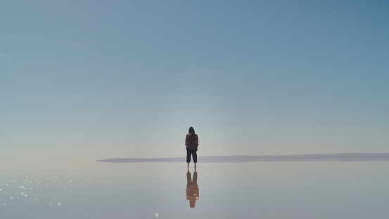 An Asian female tourist is walking in salt lake in Turkiye, Turkey.