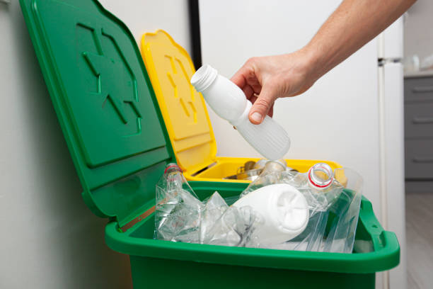 istock The man throws the plastic bottle to the one of three container for sorting garbage 1874863500