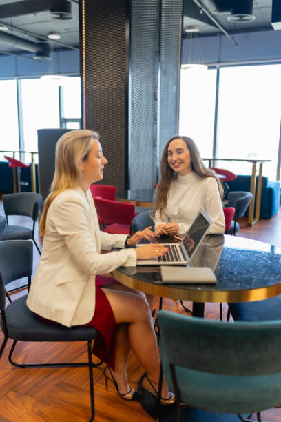 istock Happy businesswomen sit on soft chairs using laptop 1874870310