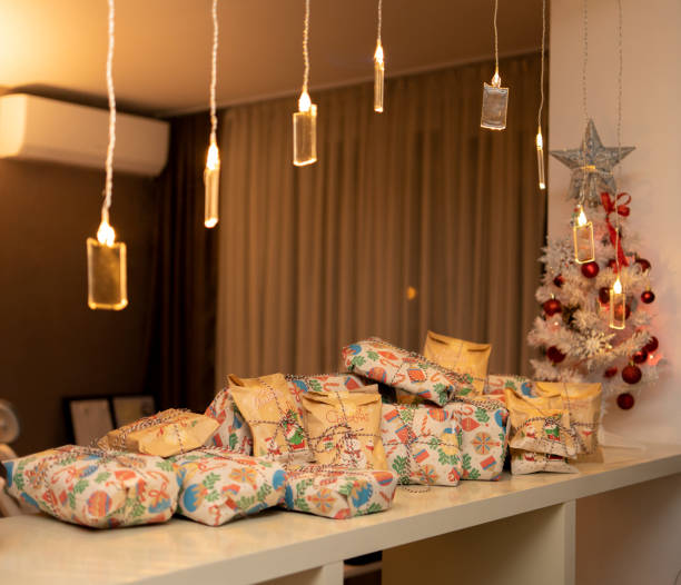 istock Christmas presents next to tree and lights garland cozy 1874881597