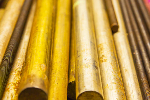 istock Large bronze round bars and steel threaded rods lie on a shelf, close-up. 1874882730