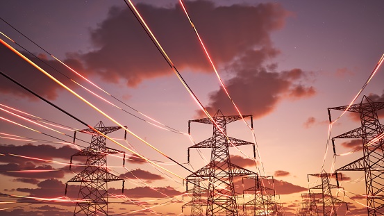 High voltage transmission towers with red glowing wires against blue sky - Energy concept