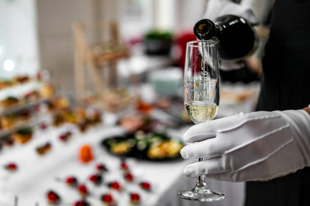 istock waiter pouring champagne wine from bottle in glasses 1874912852