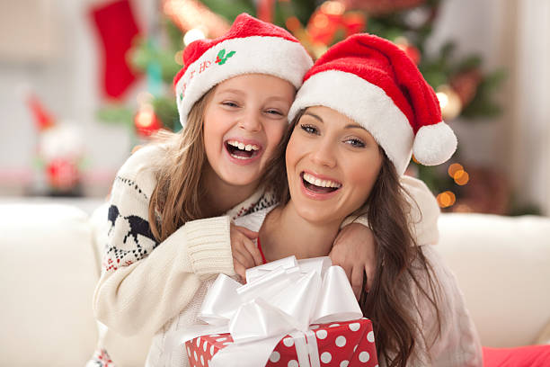 istock Mother and daughter by christmas tree. 187493956