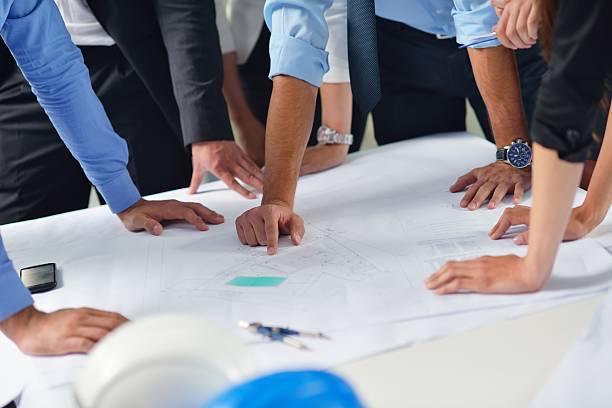 istock business people and engineers on meeting 187494436