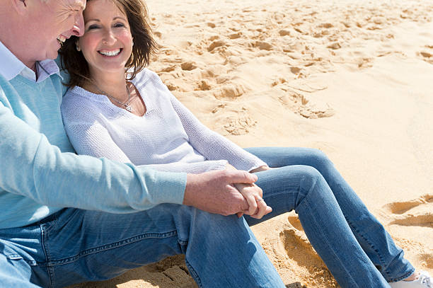 istock Happy mature couple sitting on the beach 187494890