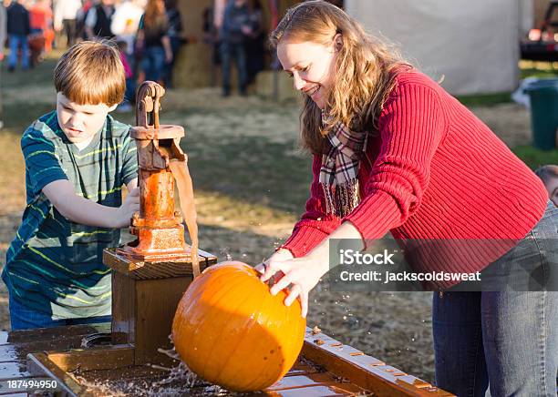 Ragazzo E Mamma Pulizia Pumpkins In Un Campo Di Zucche - Fotografie stock e altre immagini di 8-9 anni