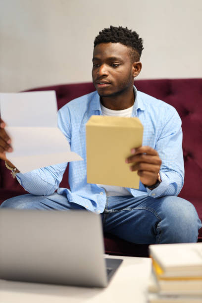 istock A young businessman working from home, surrounded by paperwork and using a laptop, showcasing a modern office setup. 1874952198