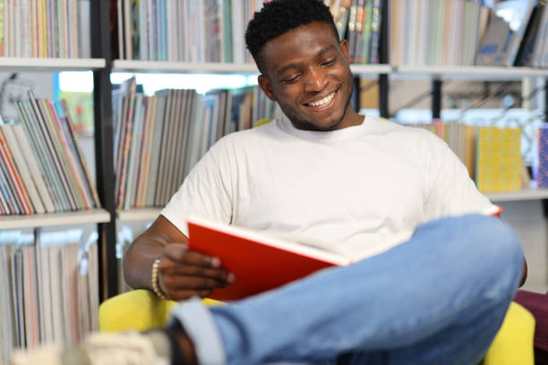 istock A happy young student immersed in studying, surrounded by books in a university library, radiating joy and academic enthusiasm. 1874952199