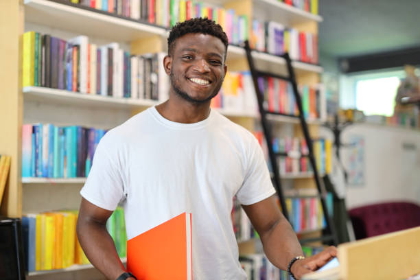 istock An intelligent and cheerful student in a university library, immersed in academic learning with a backdrop of books and bookshelves. 1874952215