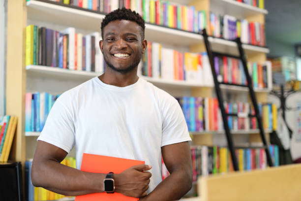 istock A diligent student in a university library, surrounded by books and bookshelves, engaged in academic learning and research. 1874952323