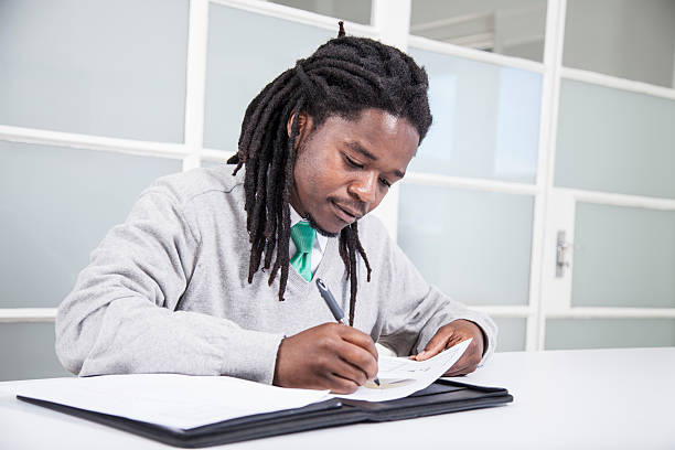 istock African businessman signing documents 187495832
