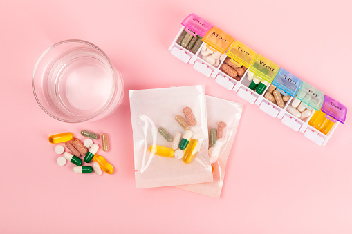 Vitamins and supplements. Variety of vitamin tablets in a pillbox on  background. Multivitamins for every day. Nutritional supplements. Flat lay. Space for text.Copy space