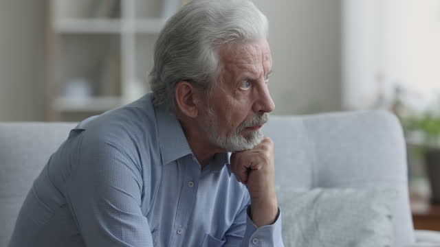 Serious thoughtful grey haired older senior man thinking on healthcare