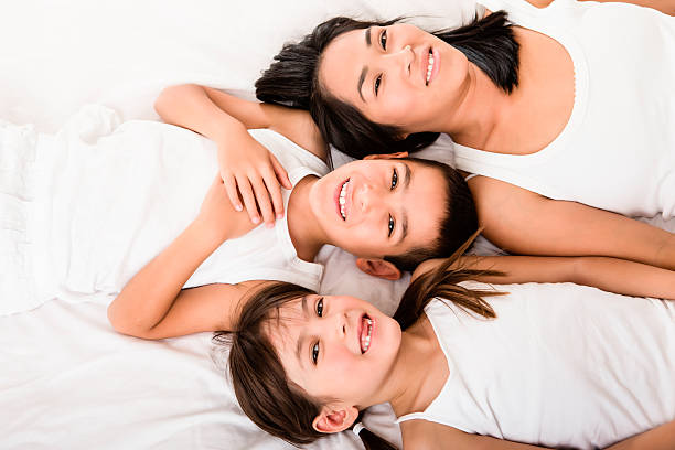 istock Mom and kids laying in bed 187497295