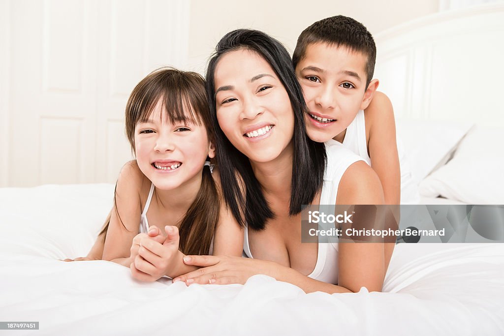 Mãe e filhos colocar na cama - Foto de stock de Menina royalty-free