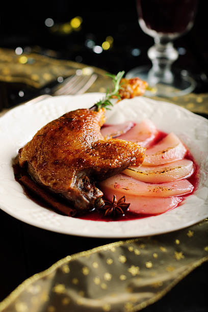 Roast Duck Leg with Red Wine Poached Pear served on a Christmas Table