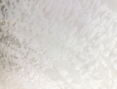 Texture on Ice sheet forming an abstract figure of whites and grays.